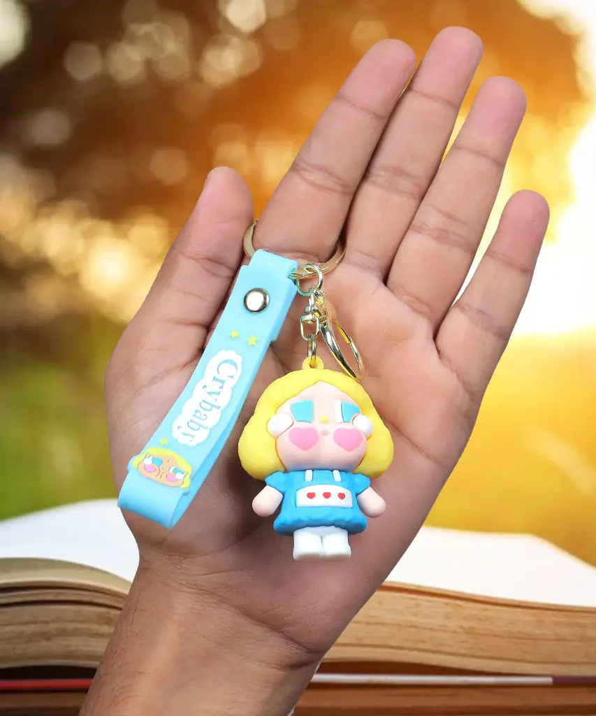 Blue Crybaby Doll Figure Keychain with Yellow Hood | "Crybaby" Logo Wrist Strap Accessory | Trendy Collectible Key Ring