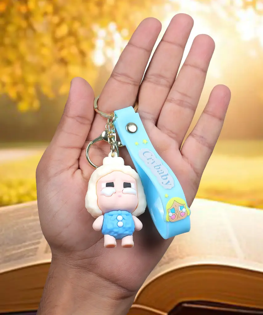 White Blue Crybaby Doll Figure Keychain with Yellow Hood | "Crybaby" Logo Wrist Strap Accessory | Trendy Collectible Key Ring