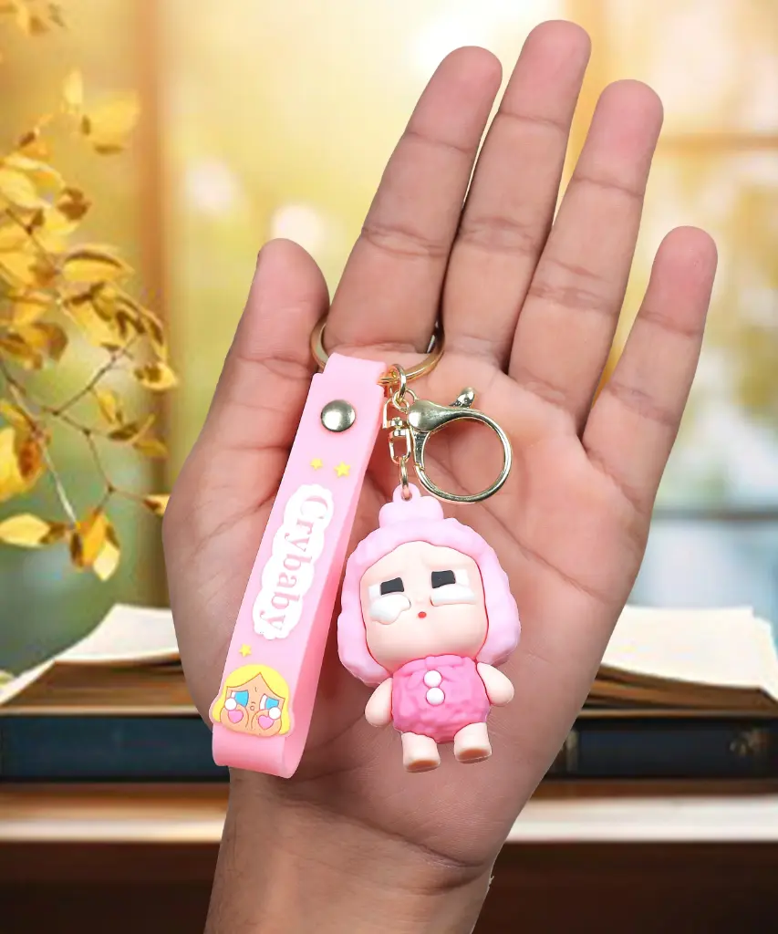 Pink Crybaby Doll Figure Keychain with Yellow Hood | "Crybaby" Logo Wrist Strap Accessory | Trendy Collectible Key Ring